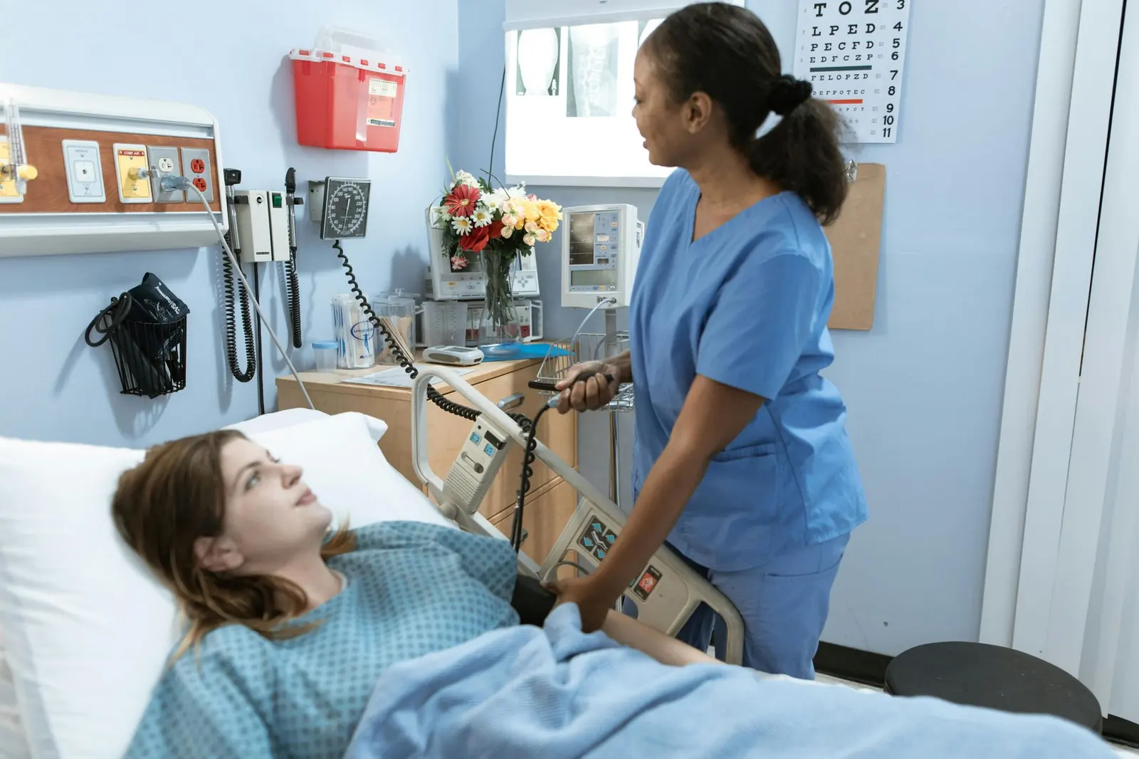 Nurse taking a patient's blood pressure in a hospital room